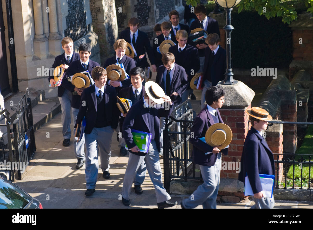 Harrow on the Hill , Harrow School Les élèves ou étudiants en uniforme marchant dans un parc avec les plaisanciers de paille traditionnel à l'heure du déjeuner Banque D'Images