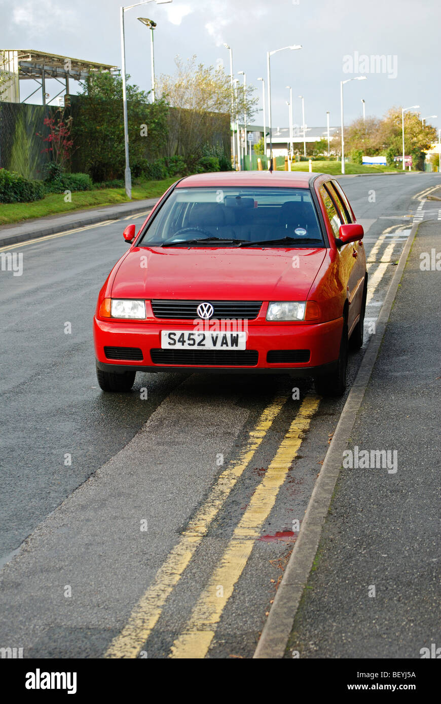 Une Volkswagen Polo rouge garé sur double lignes jaunes, Bolton, uk Banque D'Images