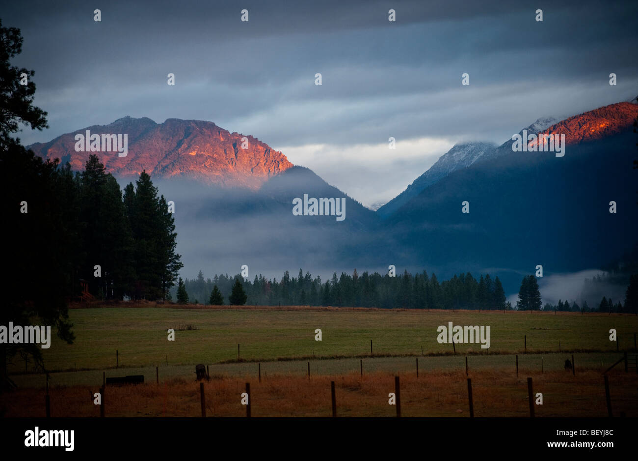 Un lever de soleil sur la vallée de Methow historique avec le brouillard en ordre décroissant sur les terres agricoles. Le soleil embrassant les montagnes environnantes. Banque D'Images