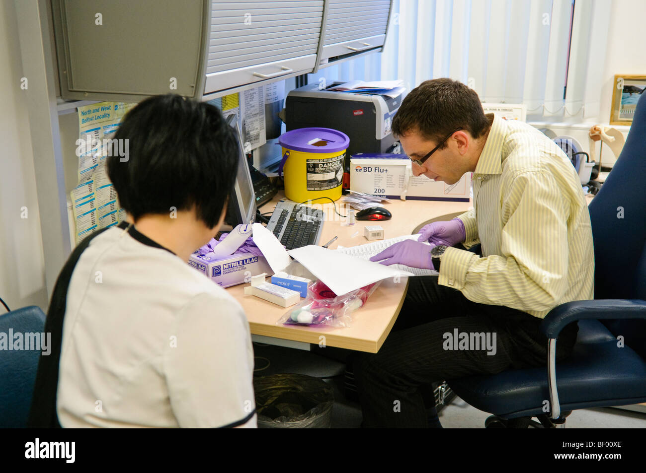 Le médecin et le patient dans une salle de consultation à un GP surgery Banque D'Images
