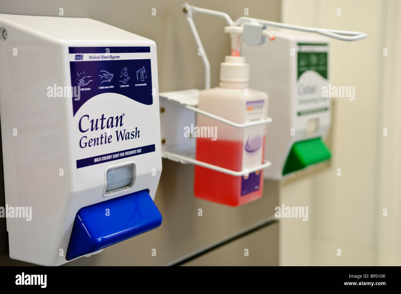 Bouteilles de lavage des mains au-dessus d'un lavabo dans une salle de consultation de chirurgie d'un GP Banque D'Images