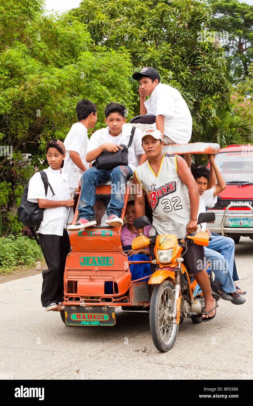 Les enfants de l'école de l'école voyage sur un tricycle à moteur. Iloilo Philippines Banque D'Images