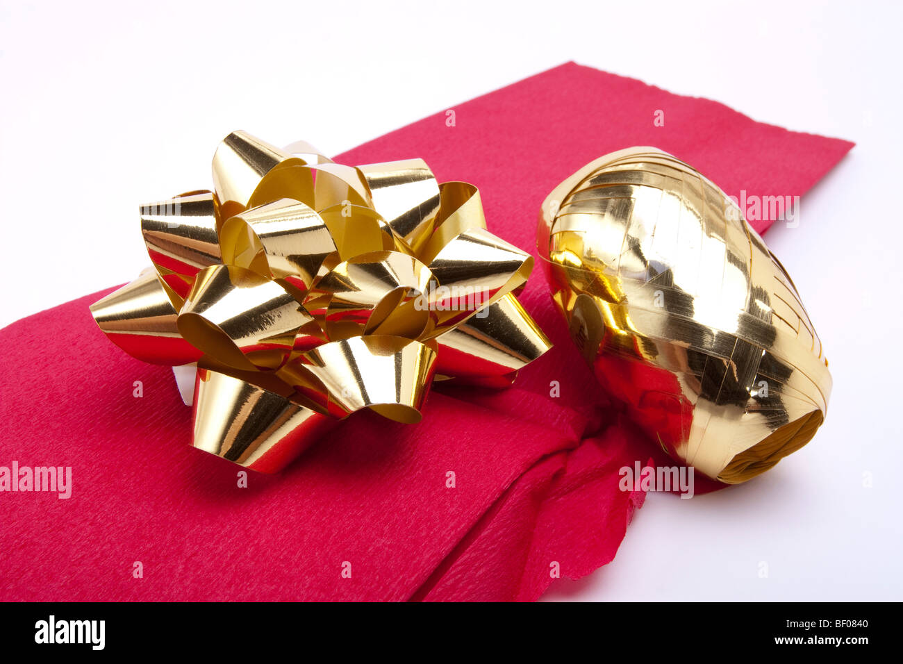 Décoration de Noël d'or et d'or bow rouleau de ruban isolés contre fond blanc coupé Banque D'Images