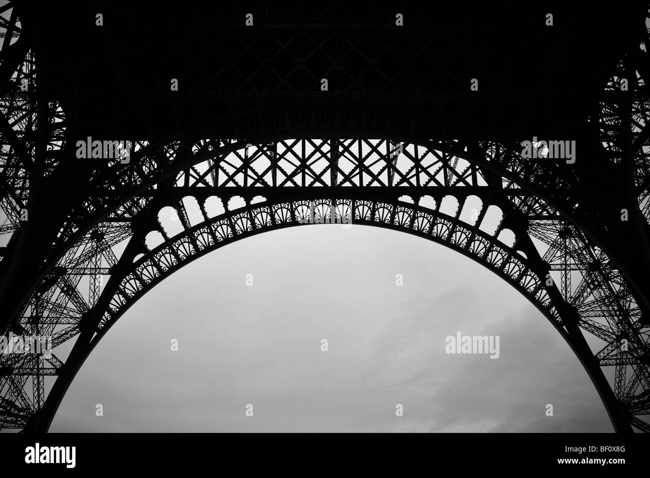 En vertu de la célèbre de France, la Tour Eiffel, dans la capitale de Paris, à la recherche jusqu'à un ciel gris nuageux. Banque D'Images