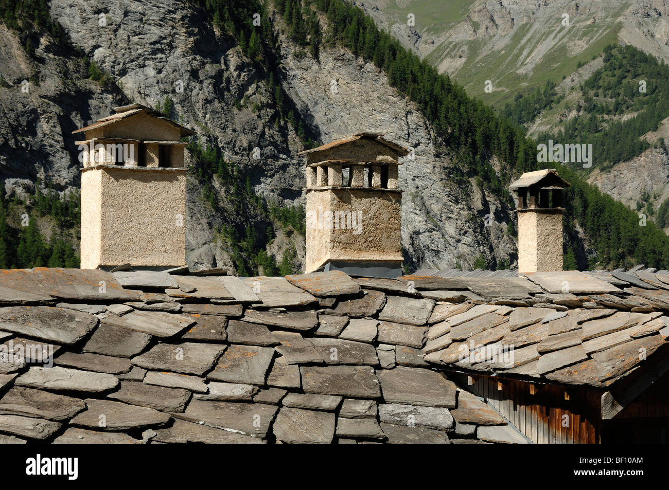 Trois cheminées en pierre et toit de tuiles à Saint-Véran ou Village Saint Véran Queyras Alpes France Banque D'Images