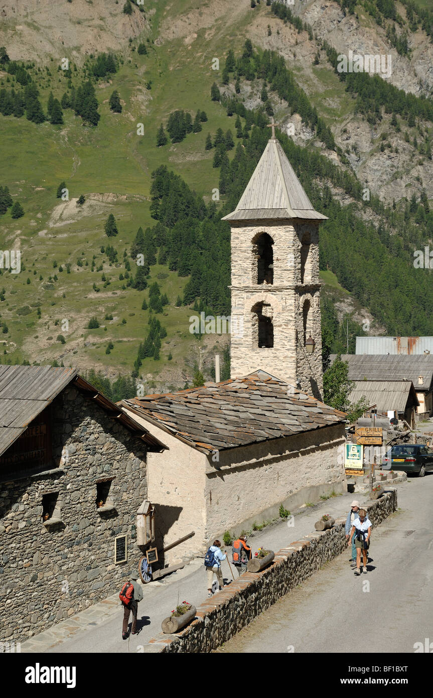 Touristes ou marcheurs à pied devant l'église protestante Saint Véran ou Saint-Véran Hautes-Alpes Queyras Parc naturel régional Alpes françaises France Banque D'Images