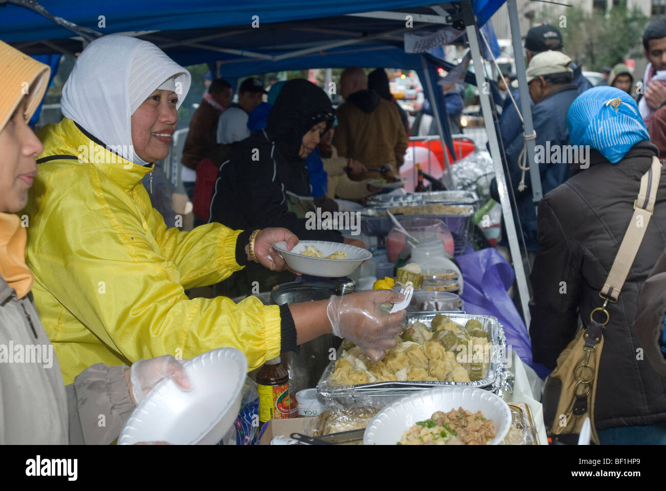 Les femmes musulmanes indonésiennes vendre des denrées alimentaires la collecte de fonds à l'aide aux victimes du séisme dans une rue juste après le Monde Musulman Day Parade Banque D'Images
