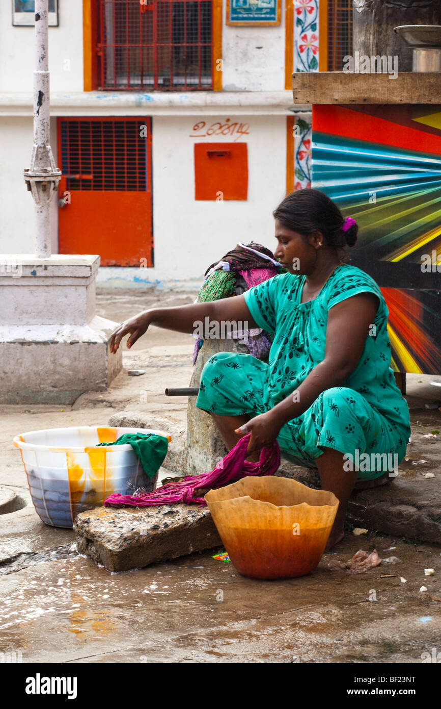 Une femme indienne se laver les vêtements sur la rue. Chennai Tamil Nadu Inde Banque D'Images