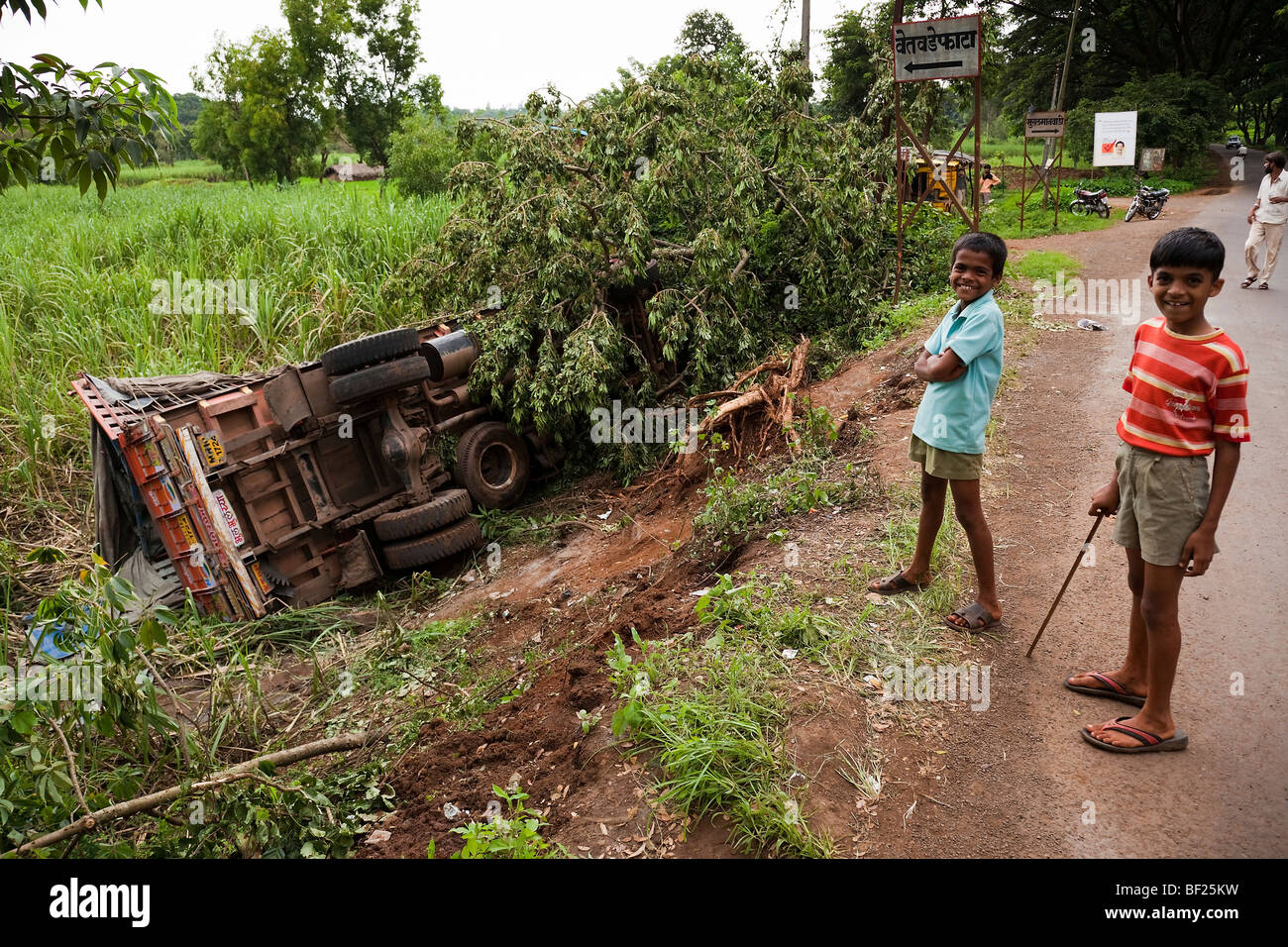 Deux jeunes garçons d'oeil à un chariot endommagé suite à un accident en Inde Maharashtra Mumbai Village Salvan Banque D'Images