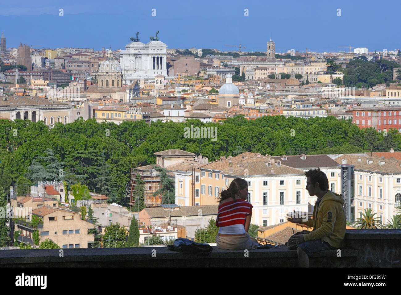 Deux personnes assis sur un mur, sur la ville de Rome, Italie, Europe Banque D'Images