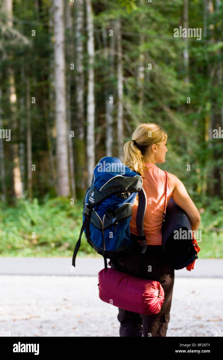 Jeune femme avec sac à dos, sac de couchage et matelas marche à travers la  forêt, Bavière, Allemagne Photo Stock - Alamy