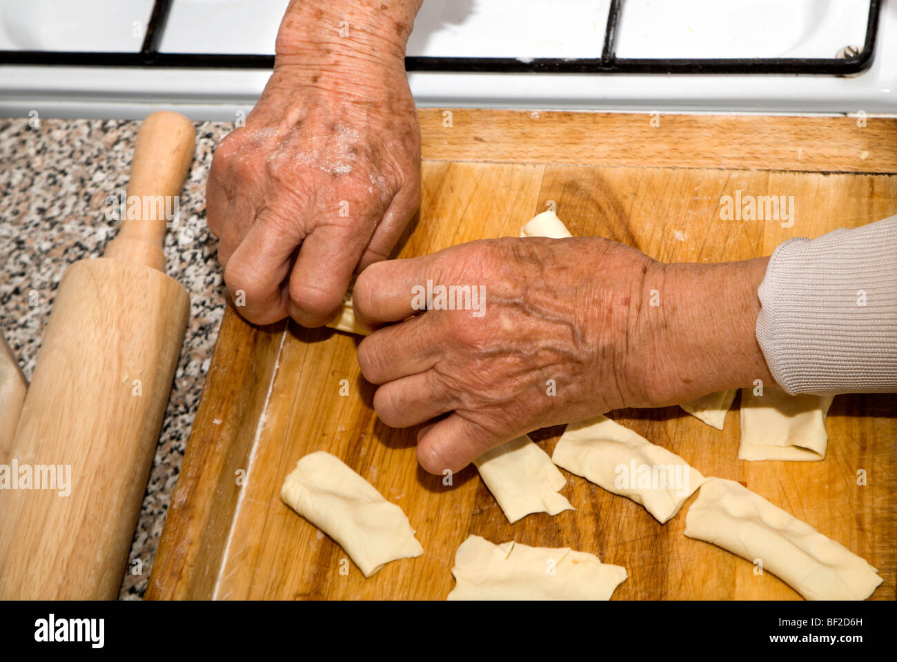 Mains de vieille femme par la cuisson Banque D'Images