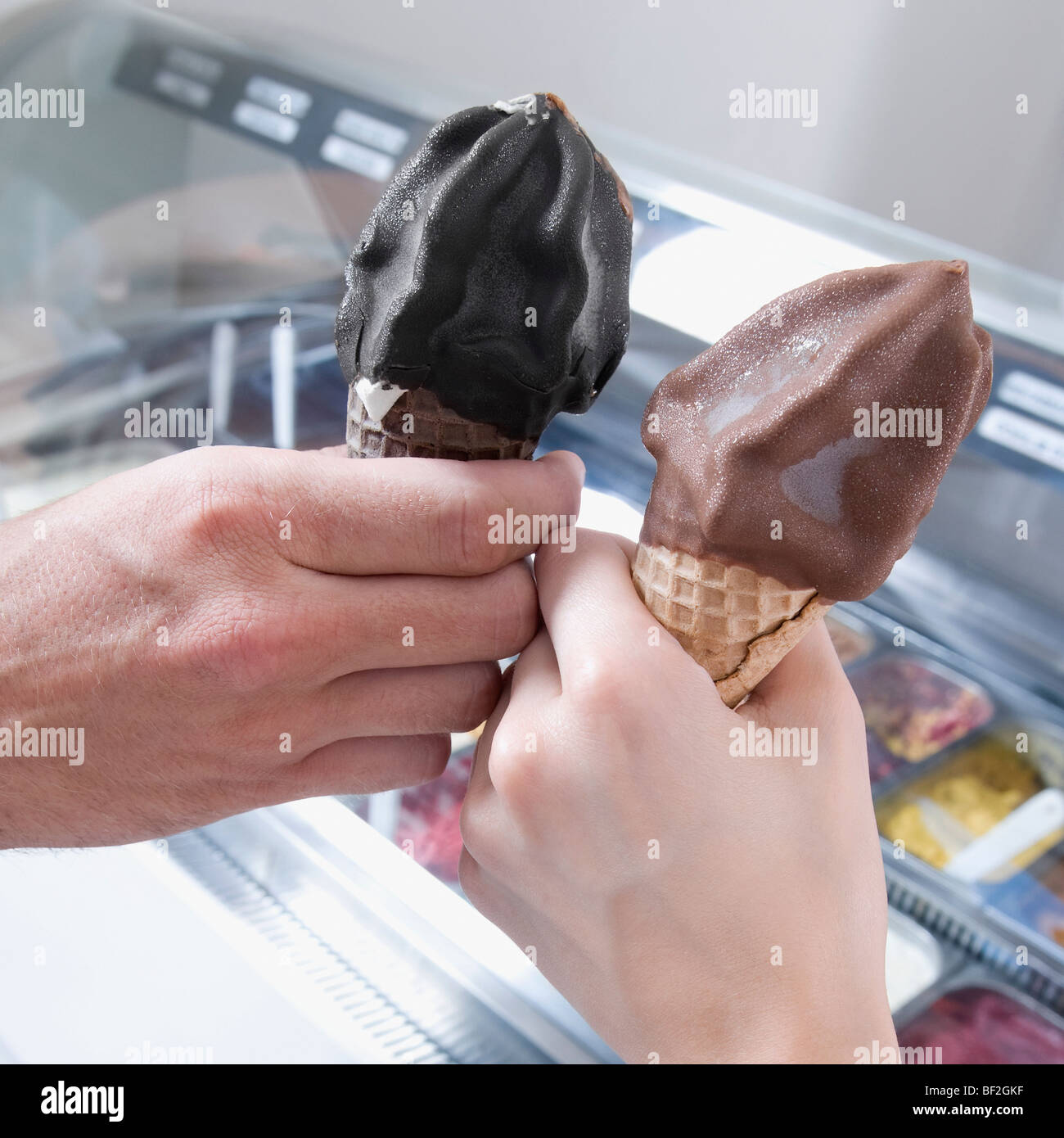 Mains d'un couple toasting with ice cream cones Banque D'Images