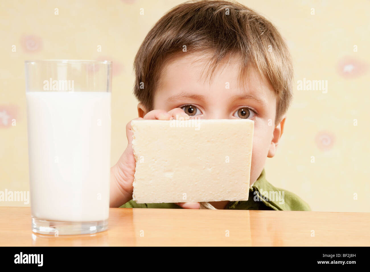 Portrait d'un garçon avec une barre de chocolat blanc et un verre de lait Banque D'Images