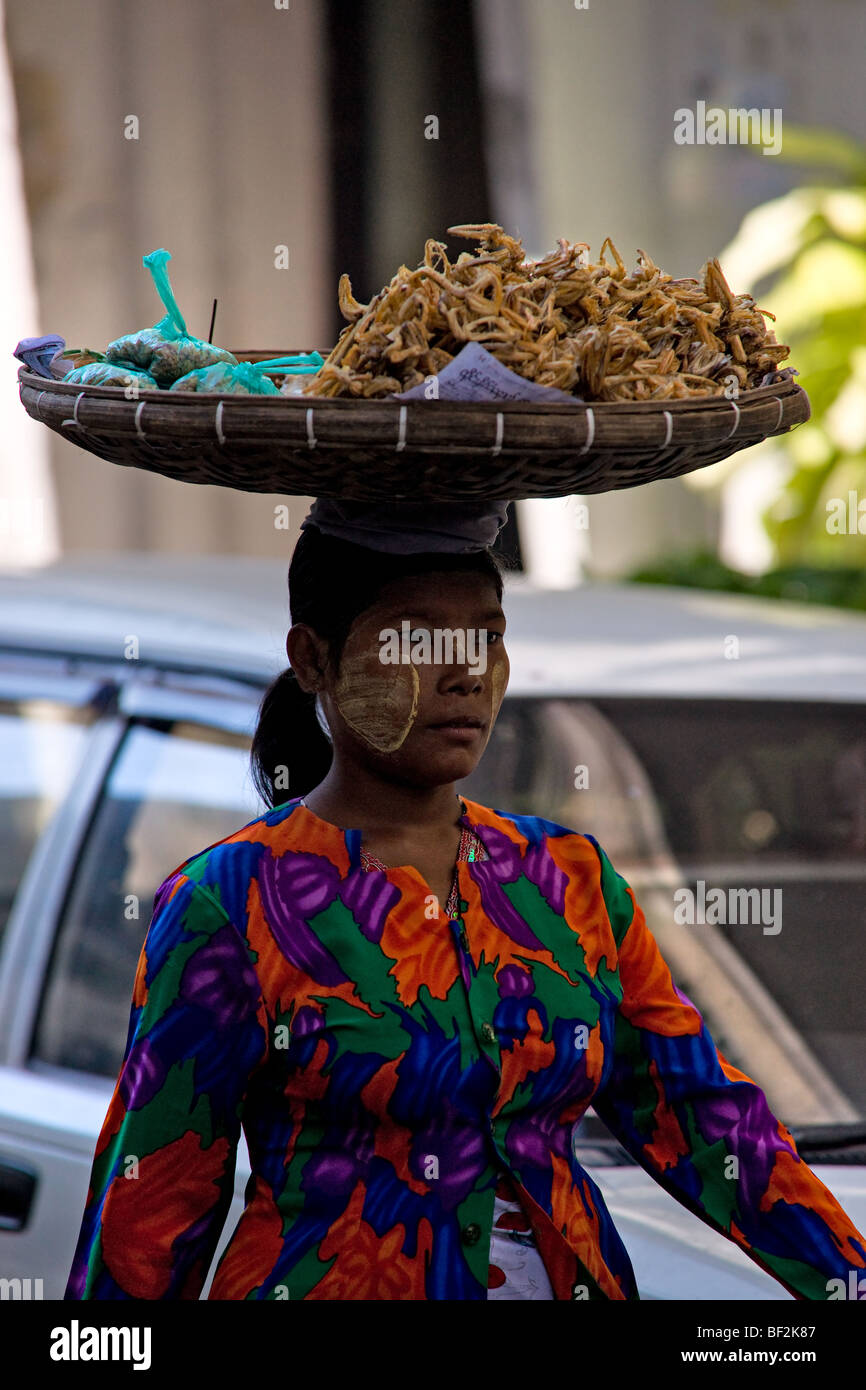 Femme avec panier sur sa tête de vendre de la nourriture, Yangoon, Myanmar. Banque D'Images