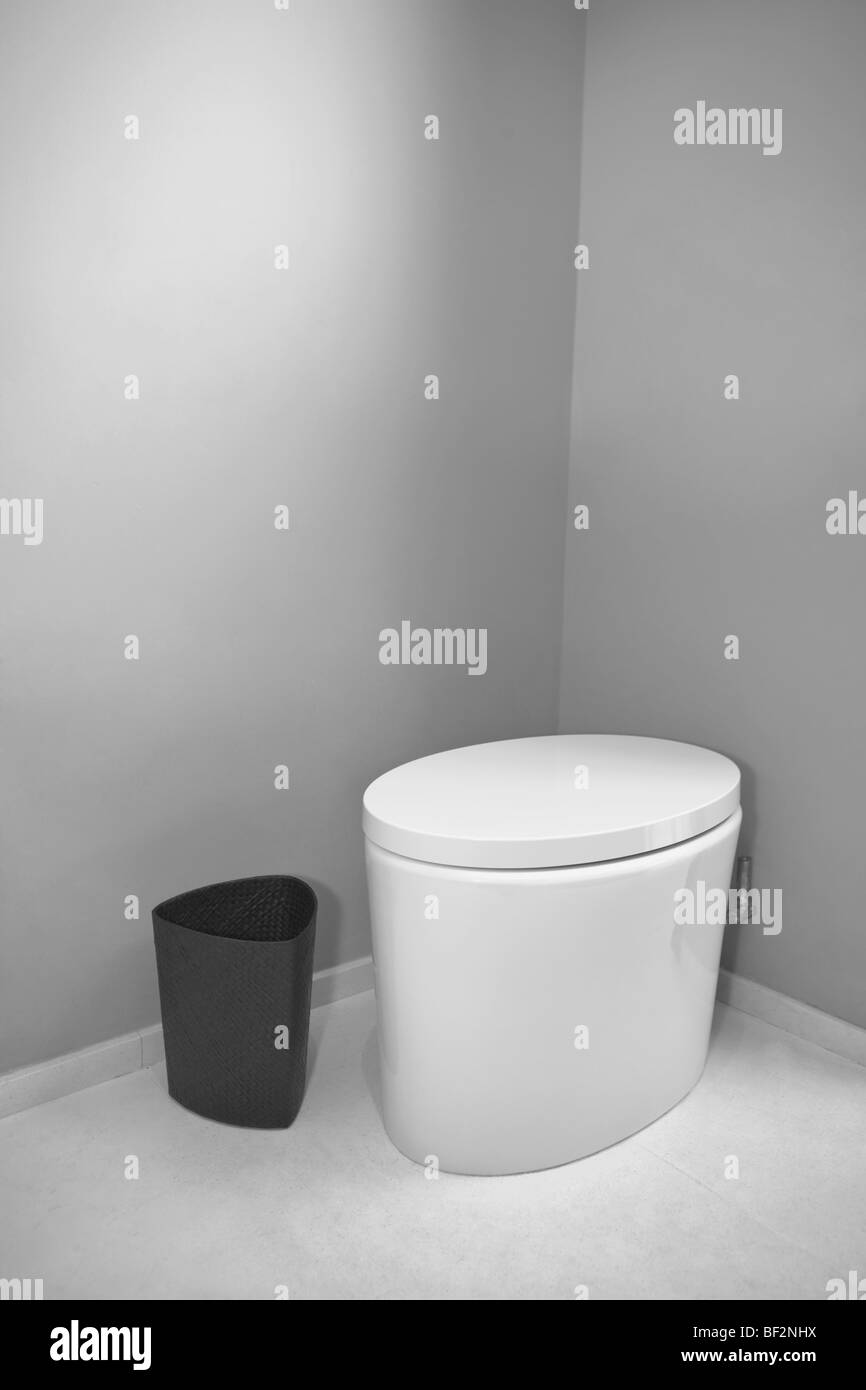 Toilettes et un conteneur de déchets dans la salle de bains Banque D'Images