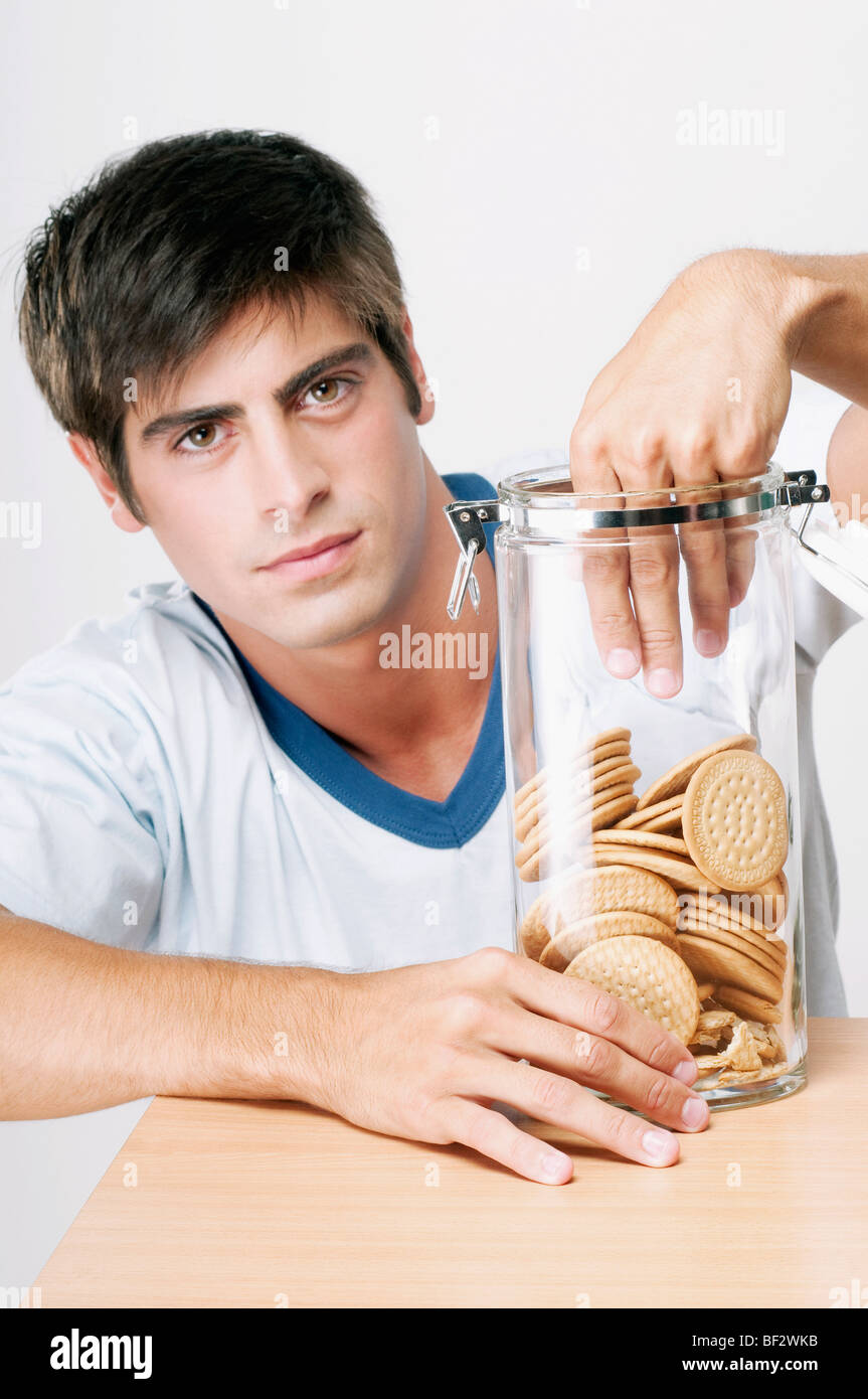 Portrait d'un homme atteint dans un bocal de cookies Banque D'Images