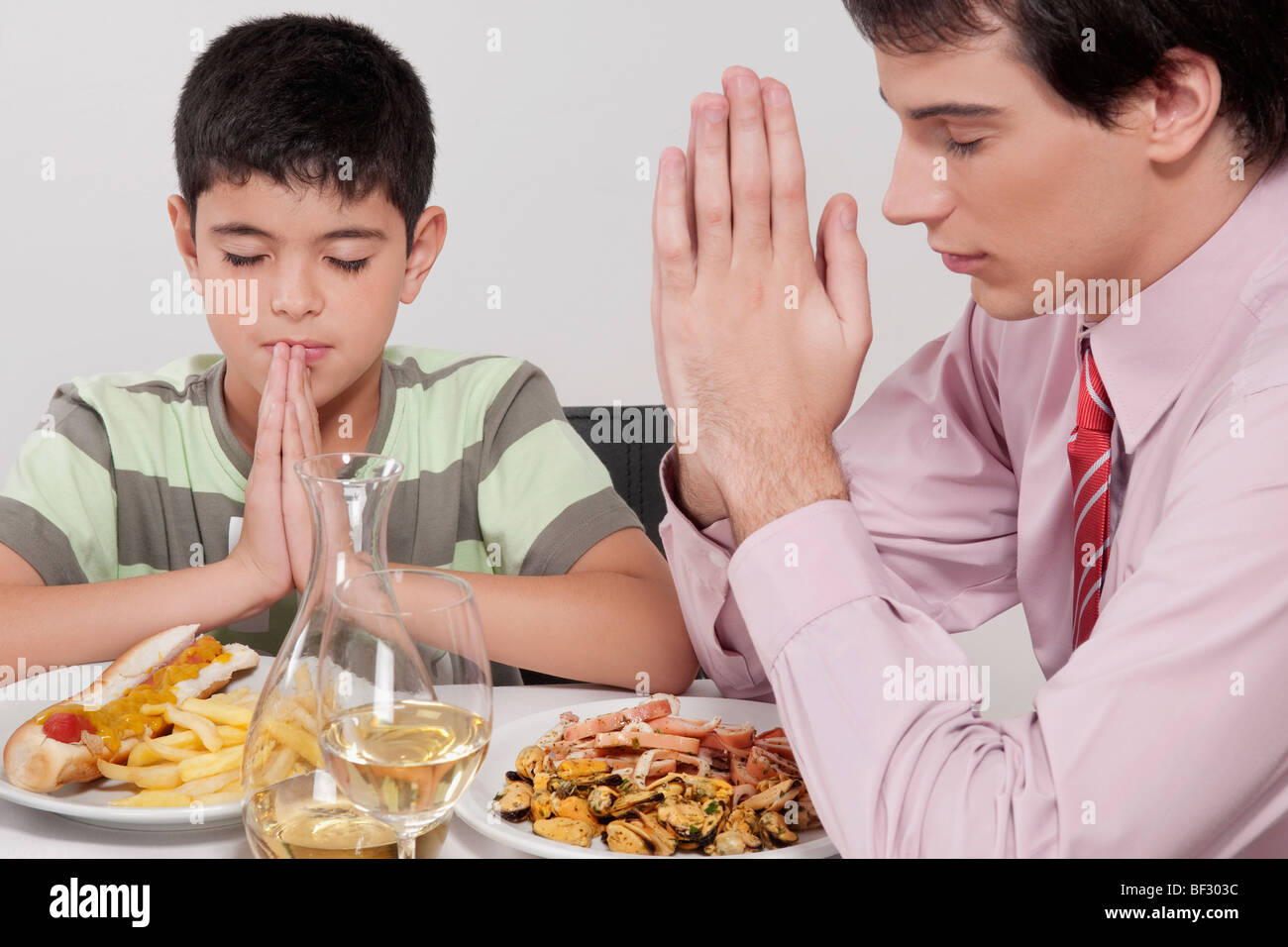 L'homme et son fils priant avant le déjeuner Banque D'Images