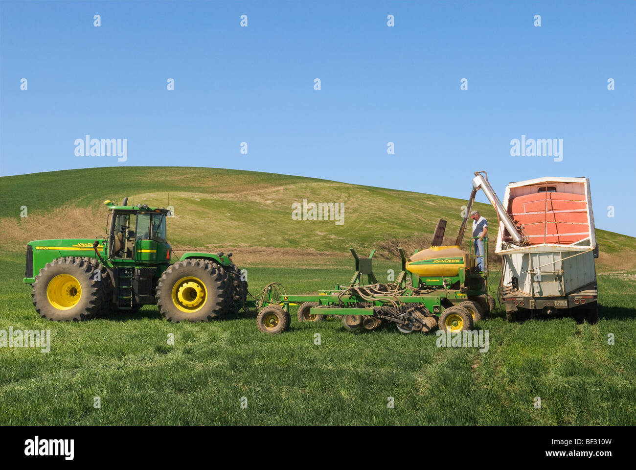 Le chargement d'un pneumatique avec les semences de blé pour reboiser les zones endommagées de la neige du blé d'hiver dans les collines de la région / USA. Banque D'Images