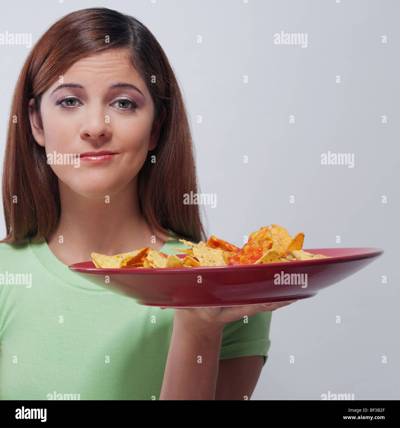 Femme tenant une assiette de nachos Banque D'Images