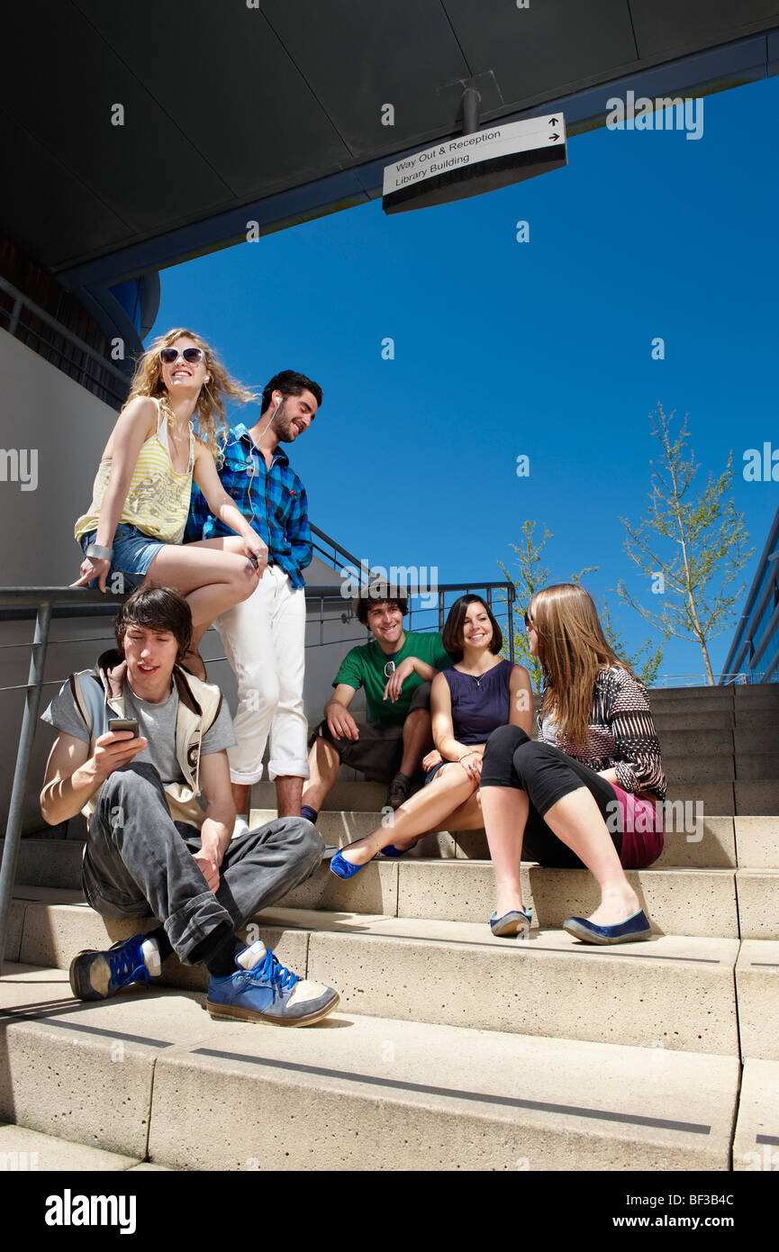 Groupe de jeunes gens assis sur les marches Banque D'Images