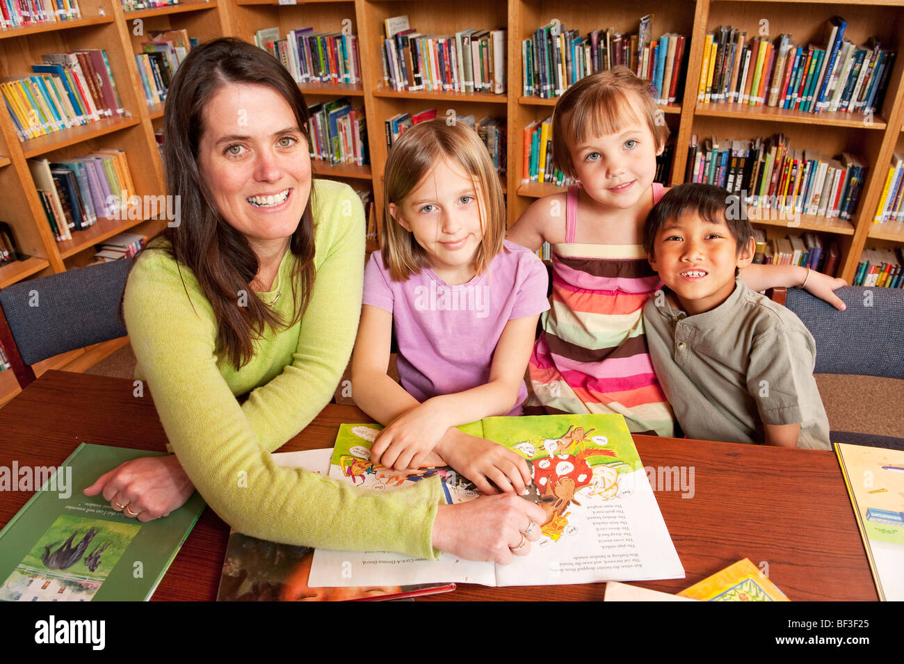 Les élèves et l'enseignant dans la bibliothèque de l'école Banque D'Images