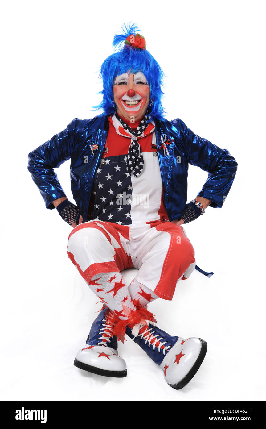 Clown sitting and smiling with hands on hips Banque D'Images