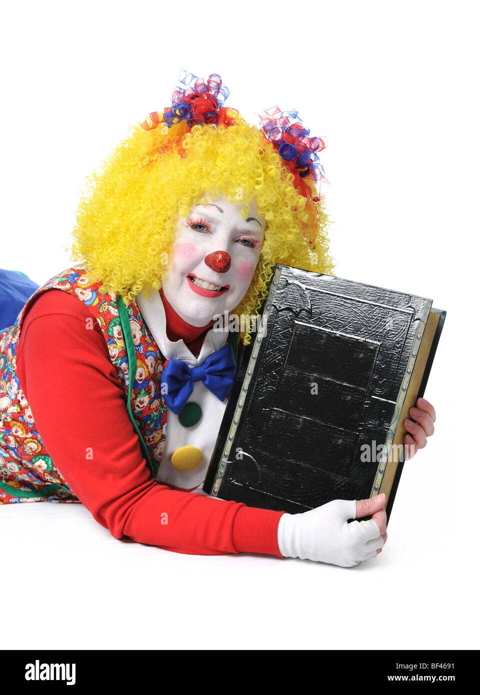 Clown holding large black book Banque D'Images