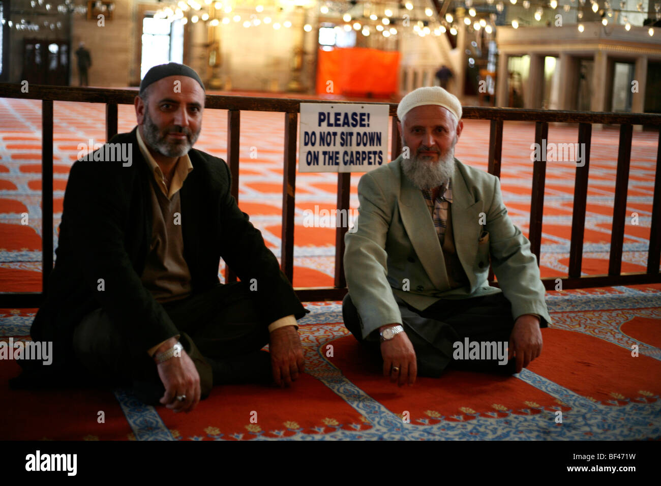 2 hommes dans la mosquée,signe d'avertissement,mosquée,touristique,vieux,hommes,assis,tapis,attention Banque D'Images