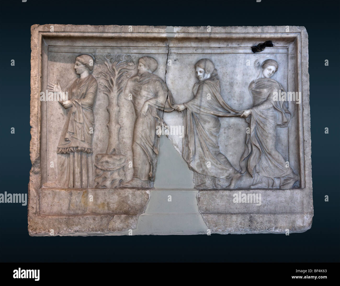 Soulagement dans le Pirée représentant un train de trois nymphes devant un autel. Une quatrième figure féminine se distingue des gestes sur la gauche. Banque D'Images