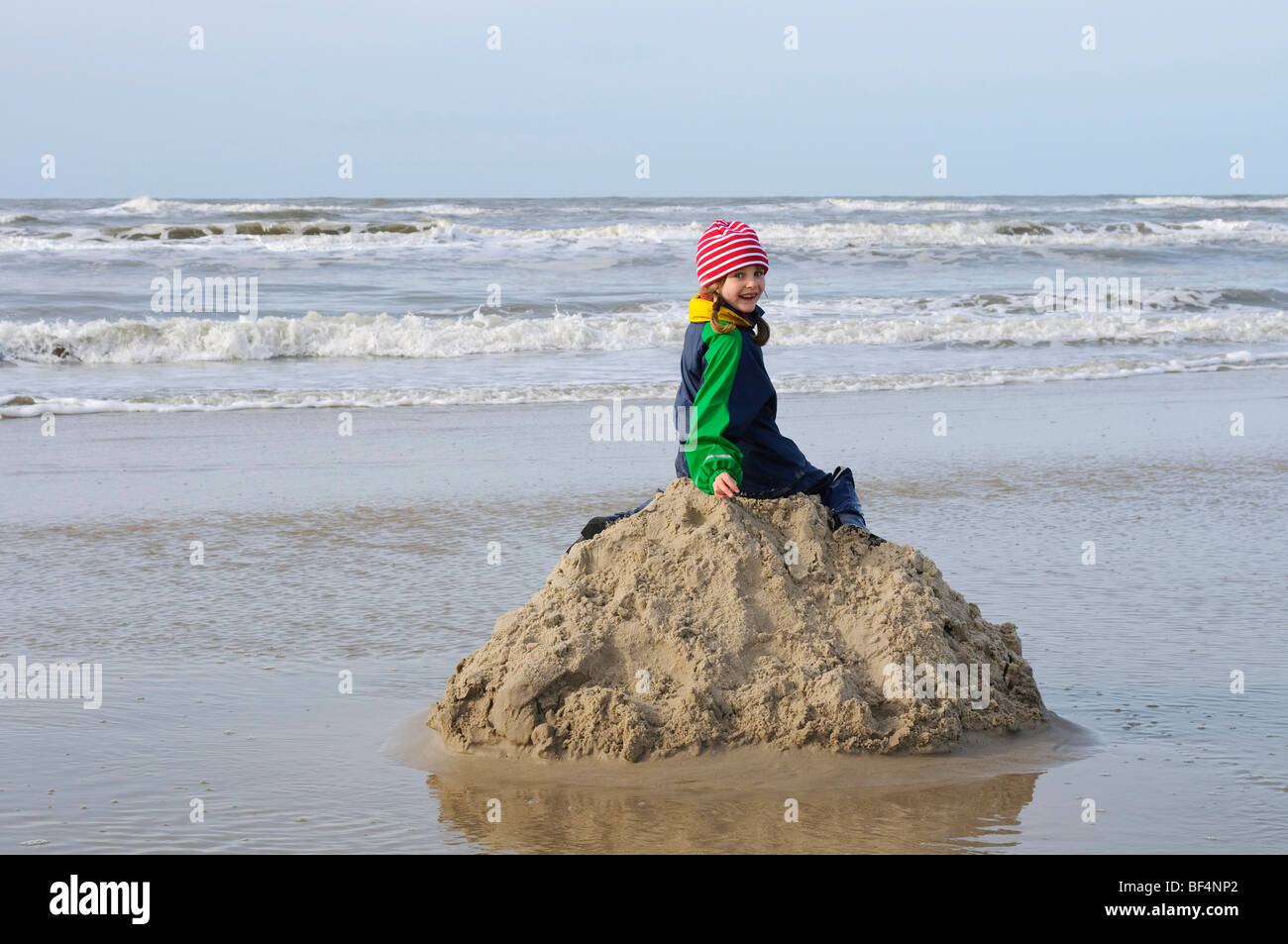 Petite fille assise sur un tas de sable sur la plage de la mer du Nord,  Vejer plage, Jutland, Danemark, Europe Photo Stock - Alamy