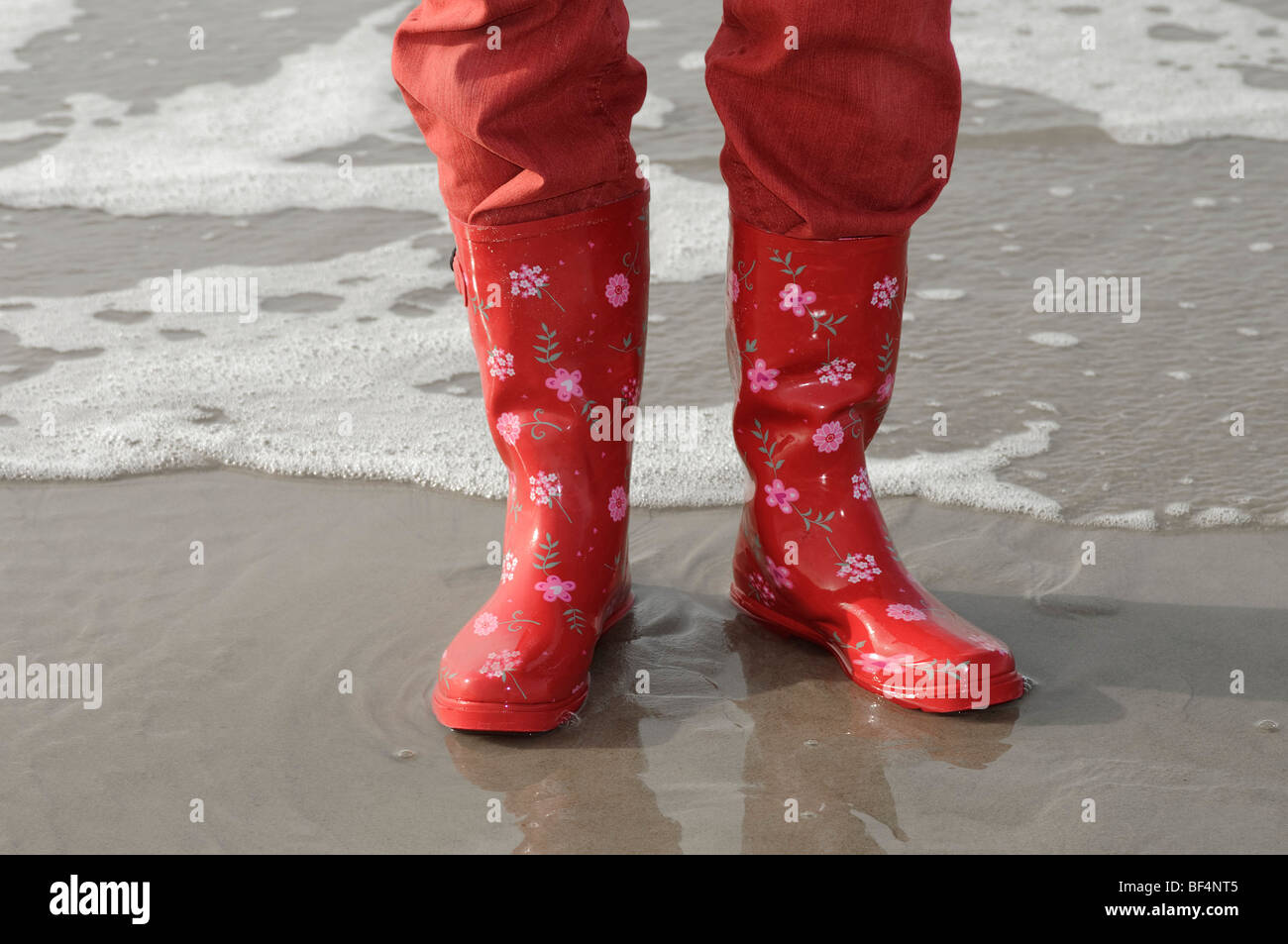 Les jambes avec un pantalon rouge et des bottes en caoutchouc rouge sur la  plage de la mer du Nord, Vejer plage, Jutland, Danemark, Europe Photo Stock  - Alamy