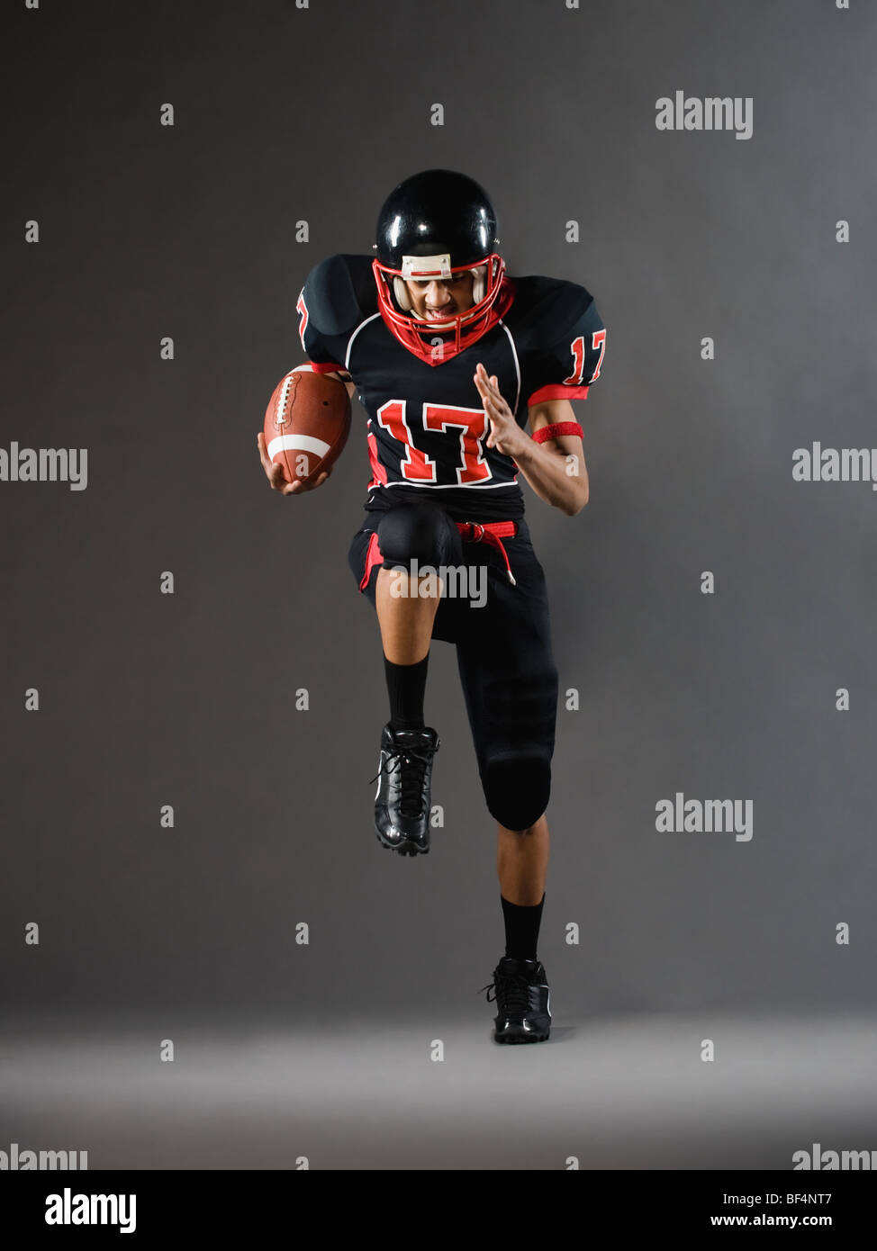 Mixed Race football player tournant avec football Banque D'Images