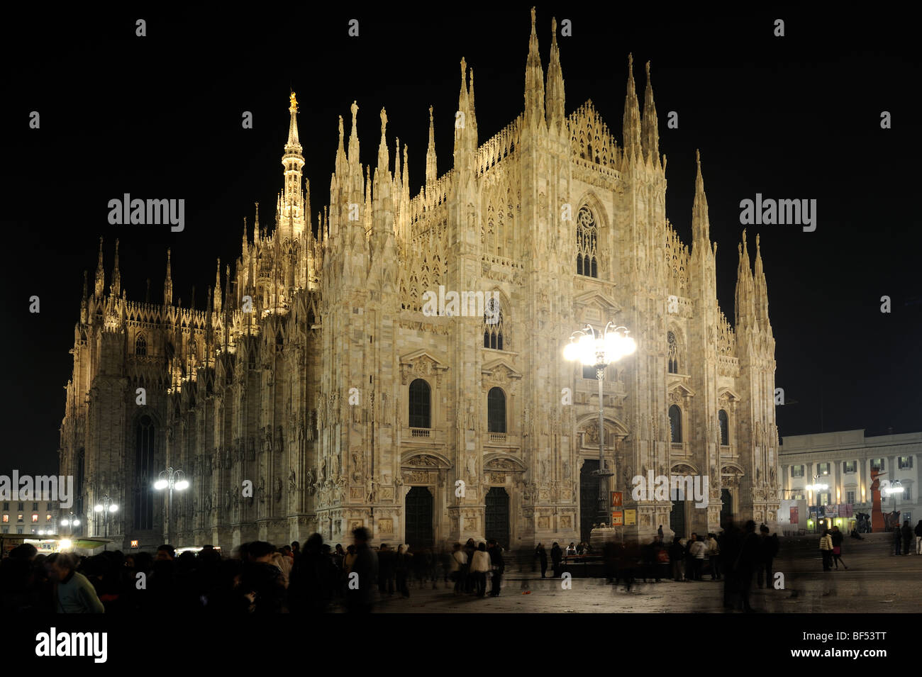 Photographie de la cathédrale de Milan, Italie, de nuit montrant le flux des gens autour d'elle Banque D'Images