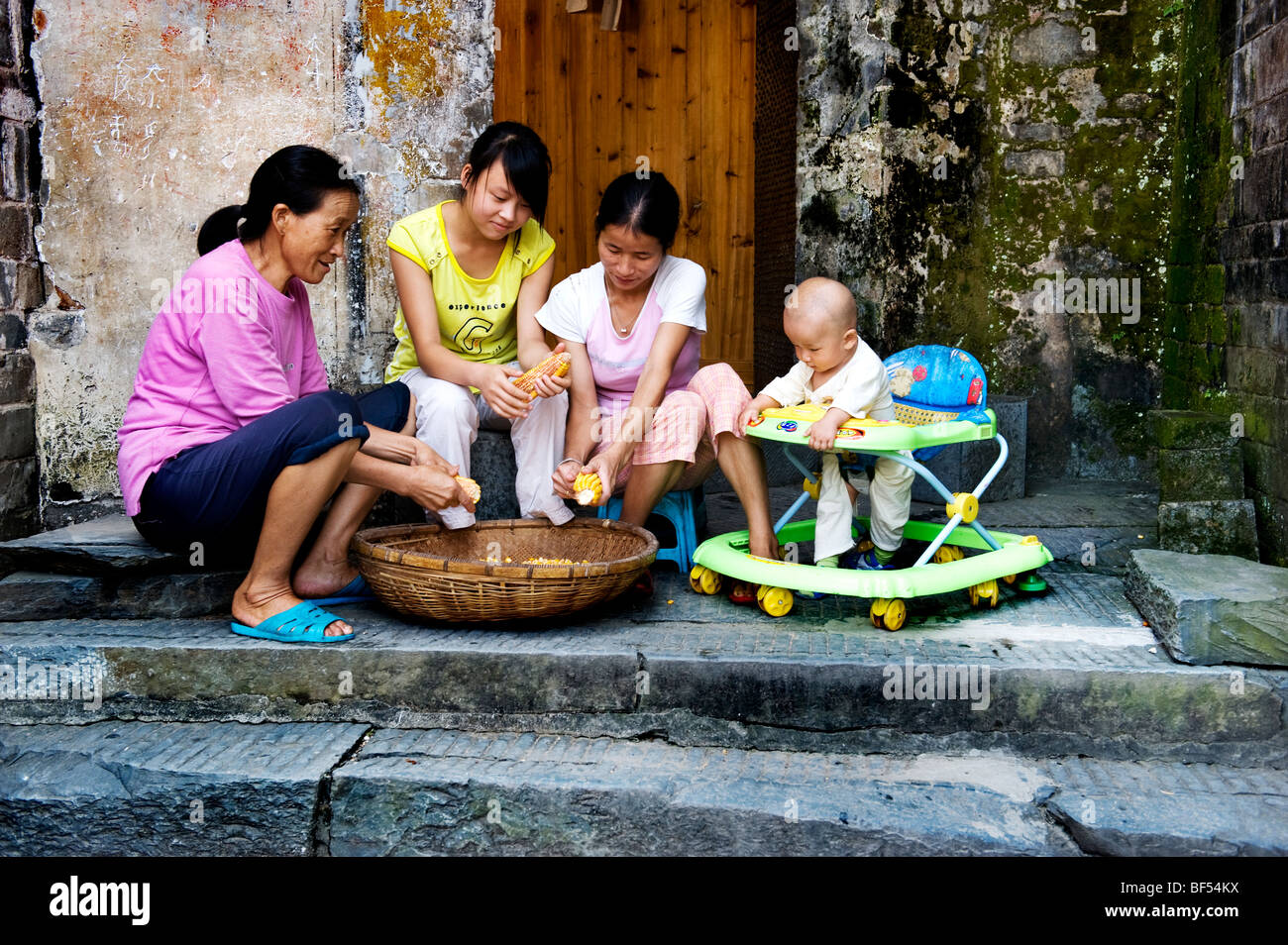 Dong femmes dans des vêtements modernes d'artillerie le maïs, Liping County, province de Guizhou, Chine Banque D'Images