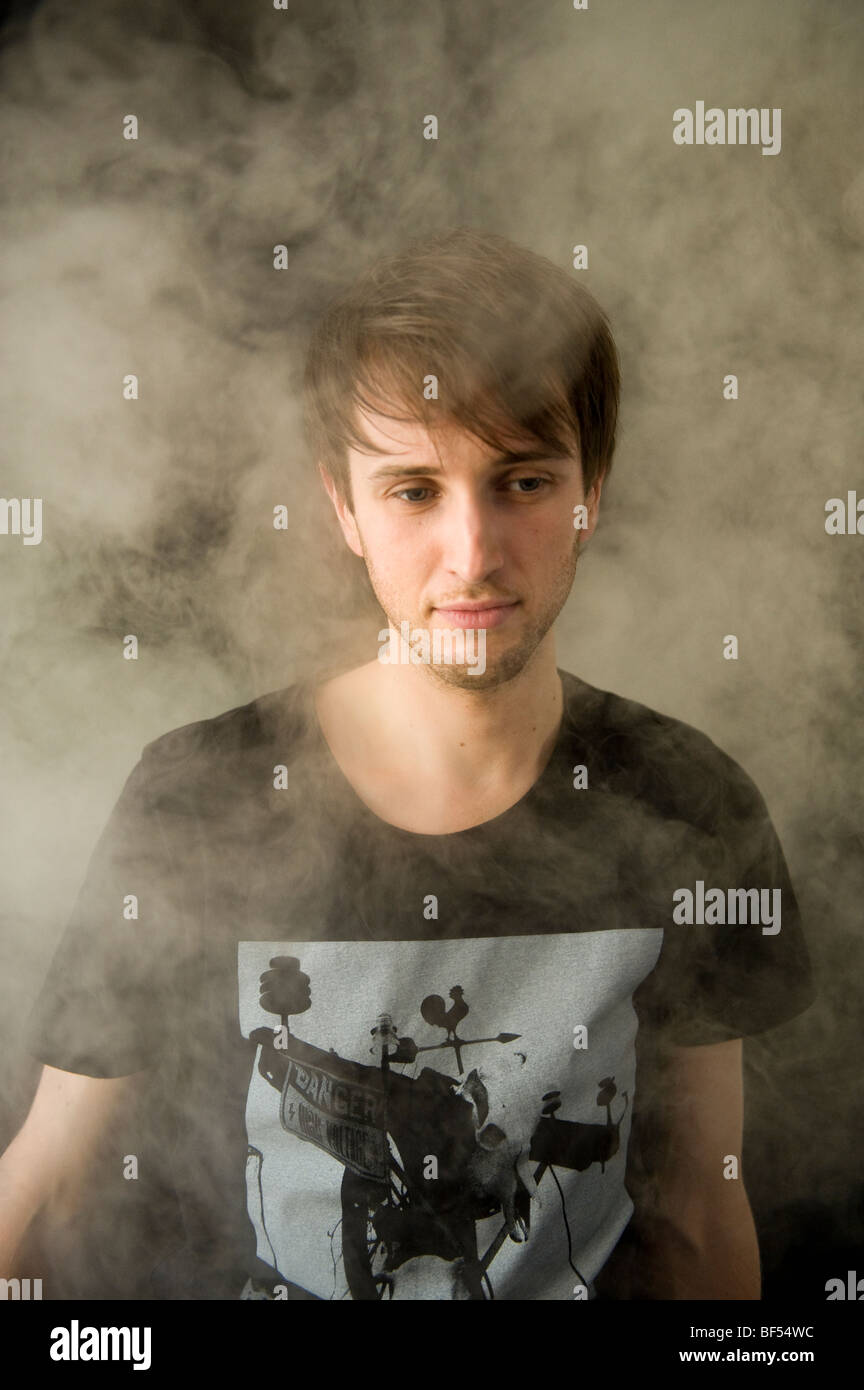 Un jeune homme pose dans une atmosphère enfumée Banque D'Images