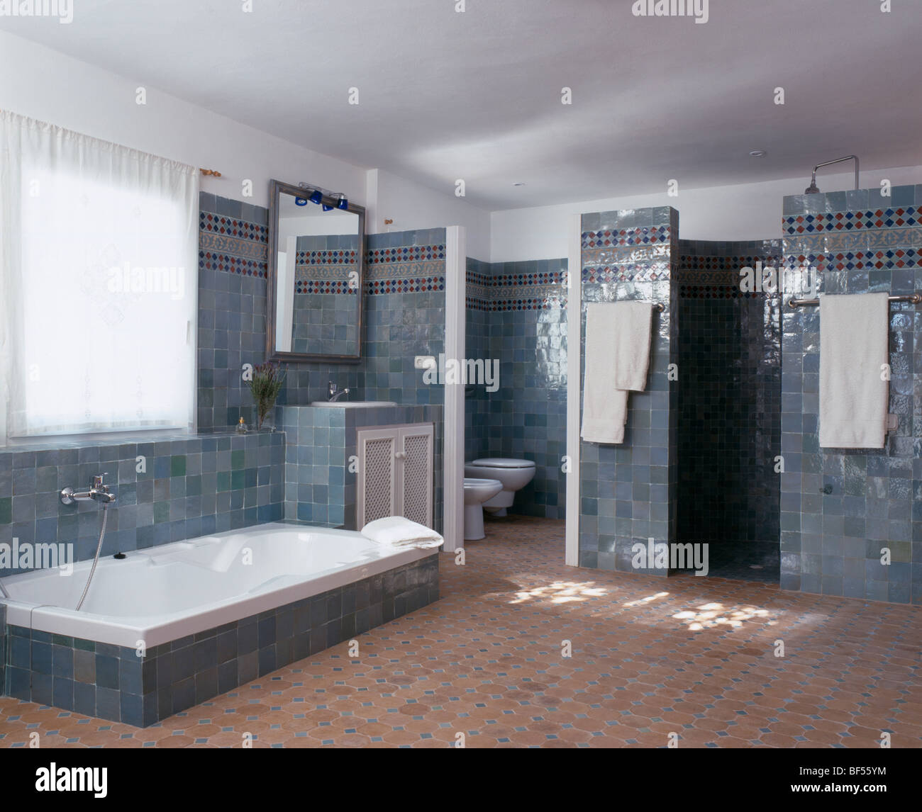 Baignoire encastrée dans le sol carrelé gris-bleu espagnol salle de bains  avec carrelage en terre cuite Photo Stock - Alamy