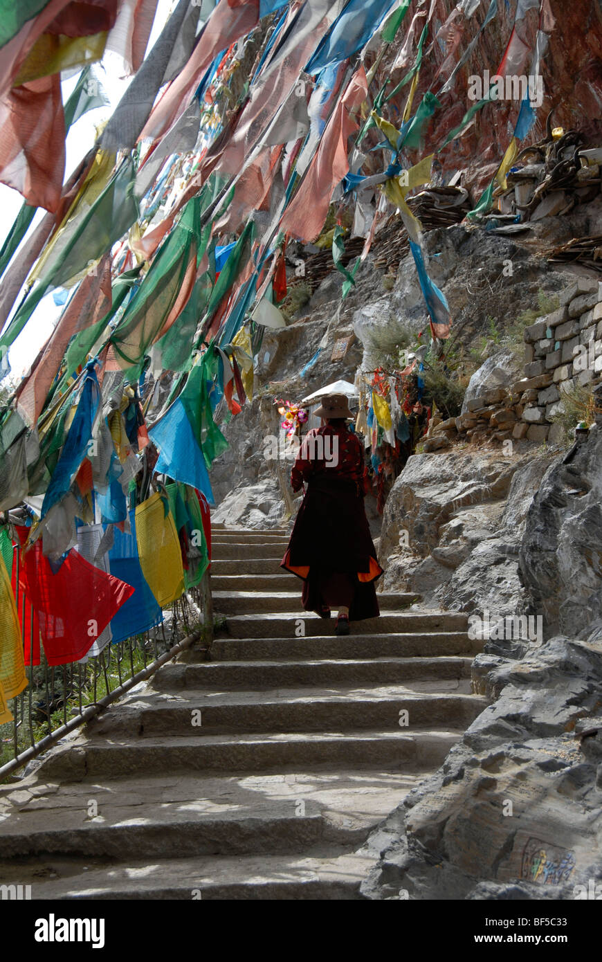 Le bouddhisme tibétain, le tibétain l'exécution d'un pèlerinage à pied le long de la Kora escaliers sous drapeaux colorés, Lhassa, Tibet, Himalaya Autonom Banque D'Images