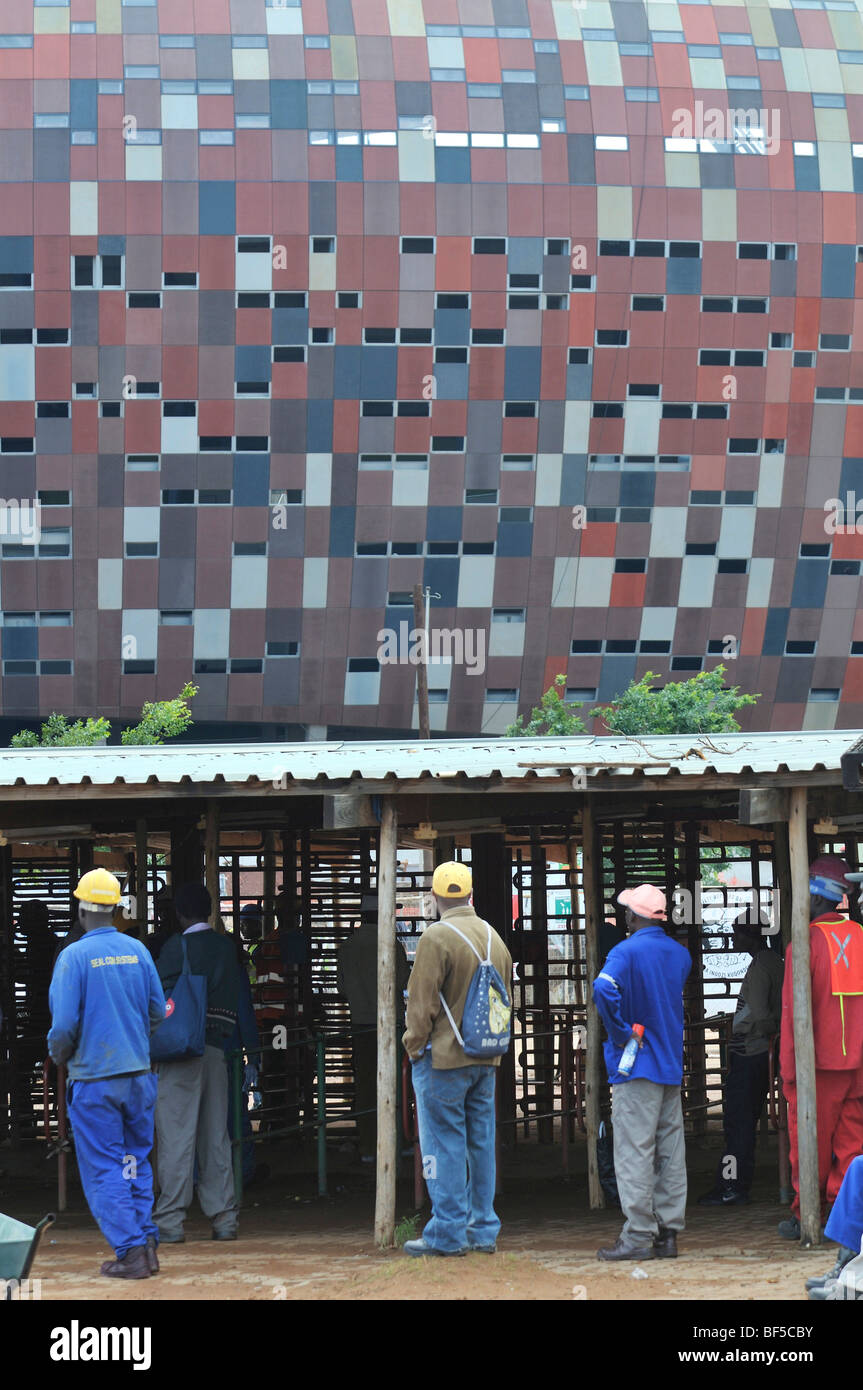 Du monde de la FIFA 2010, les jeunes hommes sont à la recherche d'emploi sur le site de construction du stade de Soccer City, à Soweto, Johan Banque D'Images