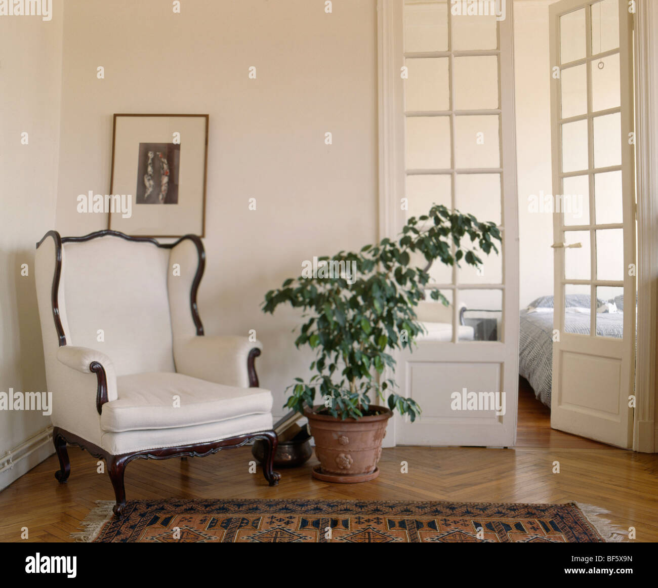 Fauteuil blanc et vert en plante d'appartement blanc hall avec des demi-double portes de chambre Banque D'Images