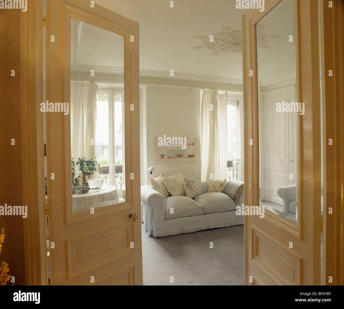 Demi-double portes ouvertes à appartement traditionnel salon avec canapé blanc et hauts plafonds Banque D'Images