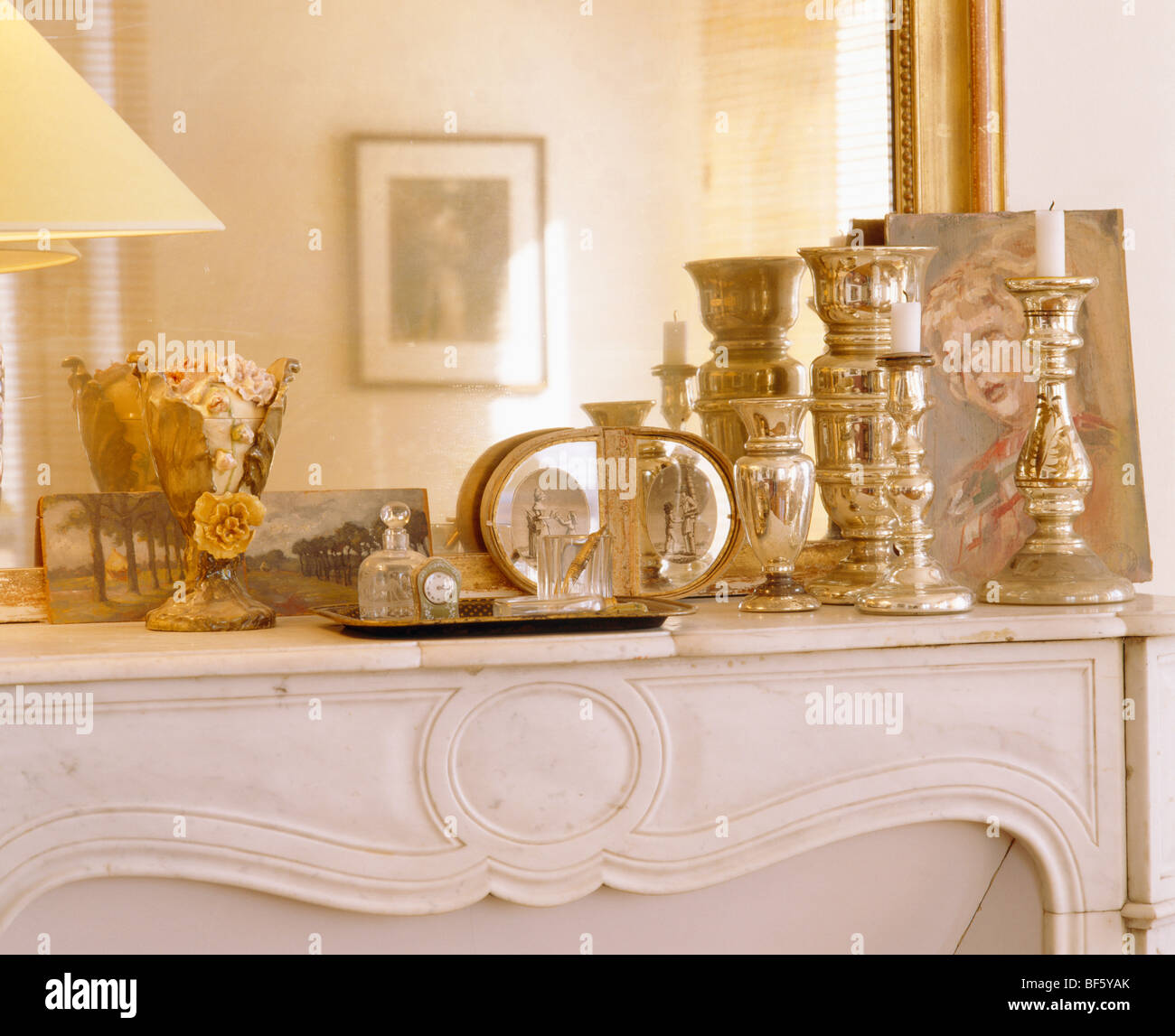 Close-up de chandeliers d'argent et de bouteilles parfum vintage en face du miroir sur la cheminée de marbre Banque D'Images