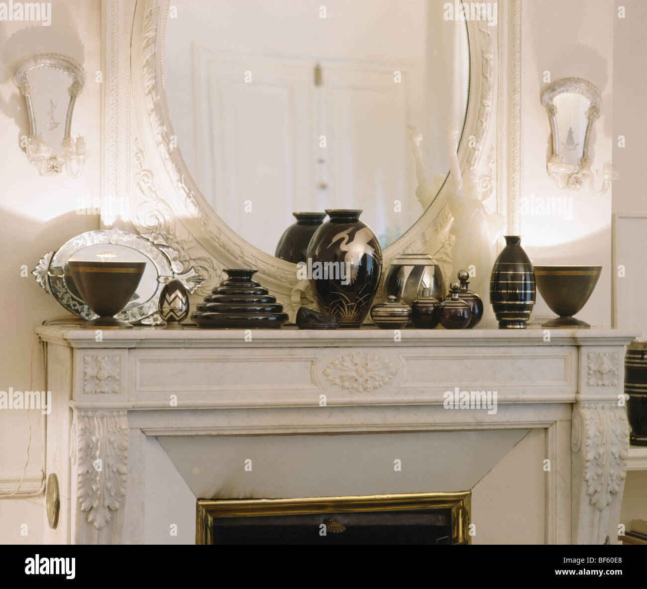 Close-up of collection de vases noir en face de miroir sur cheminée en marbre orné Banque D'Images