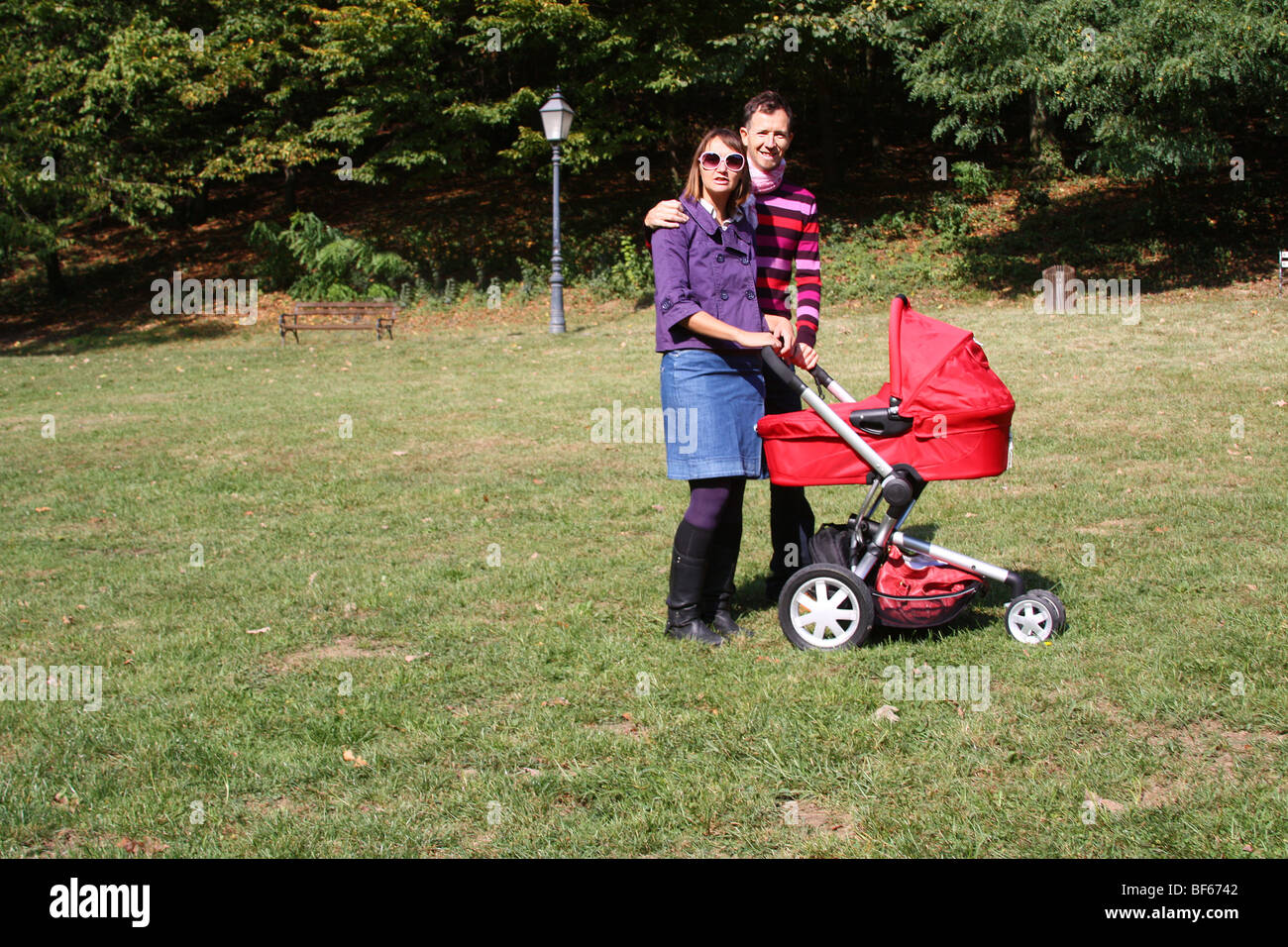 Jeune couple avec la pram en stationnement sur un jour d'automne de l'été Banque D'Images
