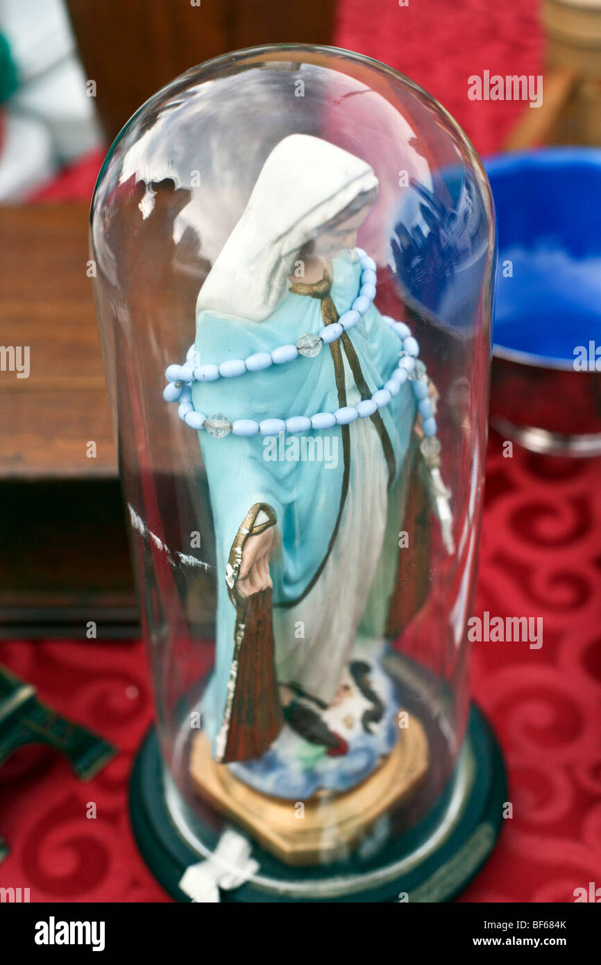 Statue Vierge Marie avec chapelet à vendre à Hells Kitchen , affiché dans bell jar reflétant le ciel et bâtiments environnants, Banque D'Images