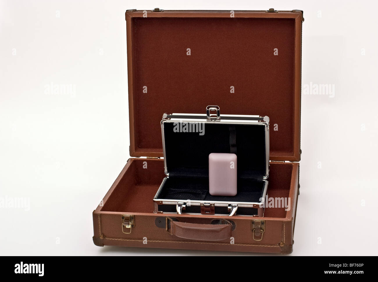Du côté d'un savon violet une boîte noire à l'intérieur d'une valise marron. Banque D'Images