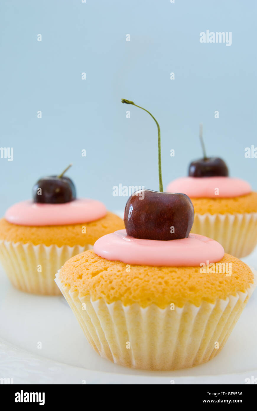 Trois cherry cupcakes recouvert sur une plaque Banque D'Images