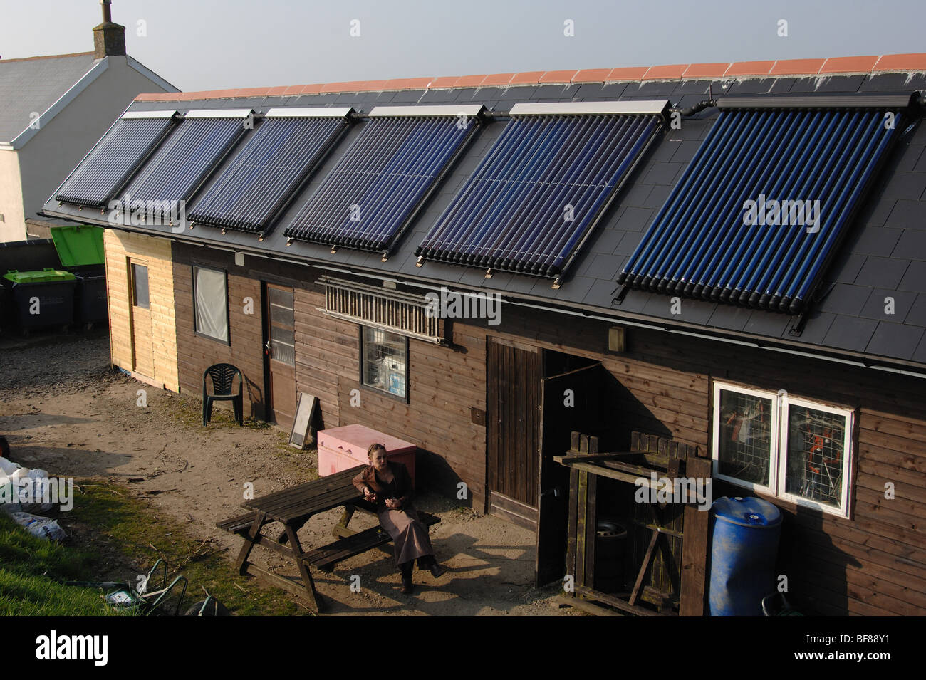 Large gamme de tubes de chauffage solaire de l'eau évacuée sur le toit d'un centre d'activités de plein air dans le nord du Devon england uk Banque D'Images