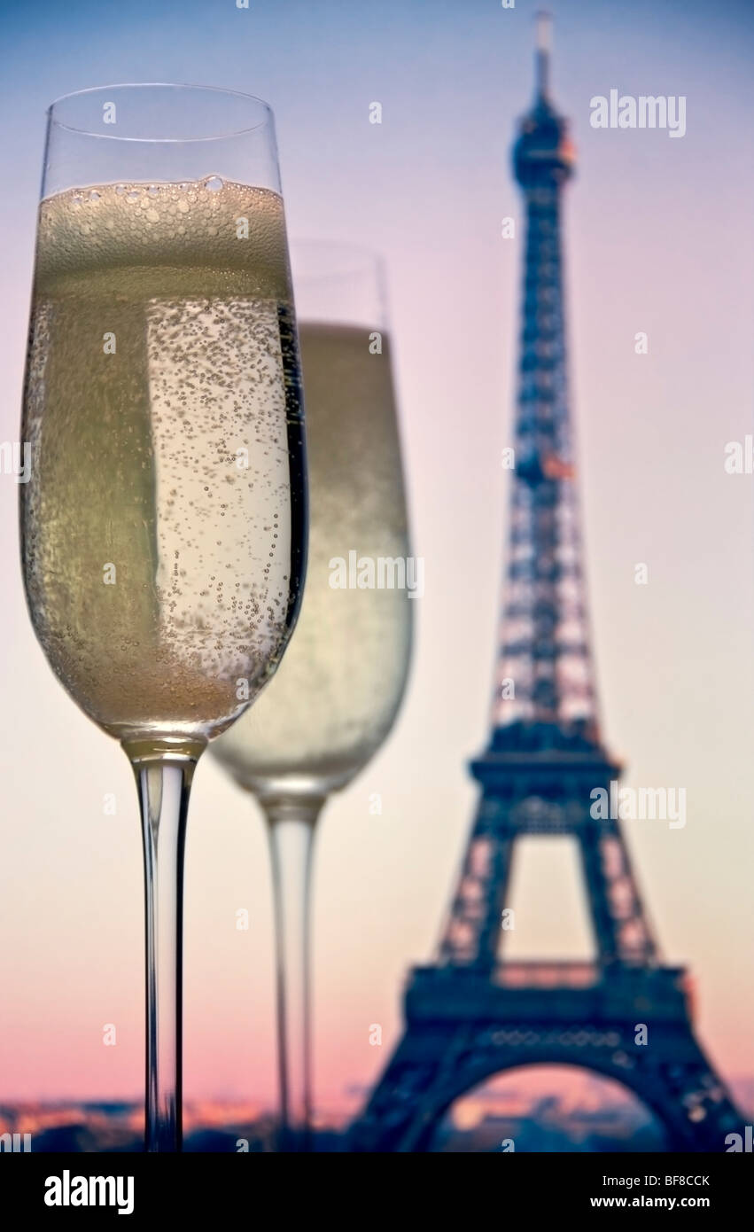 Terrasse avec vue sur PARIS CHAMPAGNE deux verres de champagne à la Tour Eiffel au coucher du soleil derrière. Paris France Banque D'Images