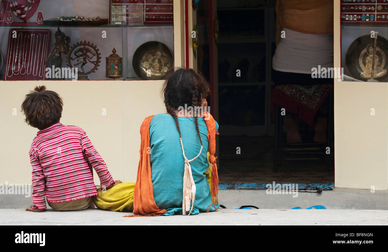 Deux enfants mendiants indiens attendent impatiemment à l'extérieur d'un magasin pour un tourisme de l'ouest pour sortir. Puttaparthi, Andhra Pradesh, Inde Banque D'Images